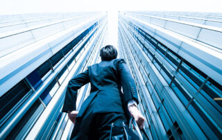 homme en costume regardant vers le haut d'un immeuble d'affaires