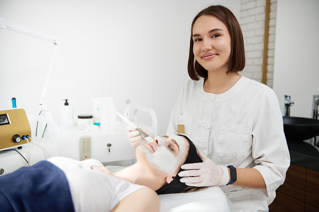 esthéticienne prodiguant un soin du visage à une cliente