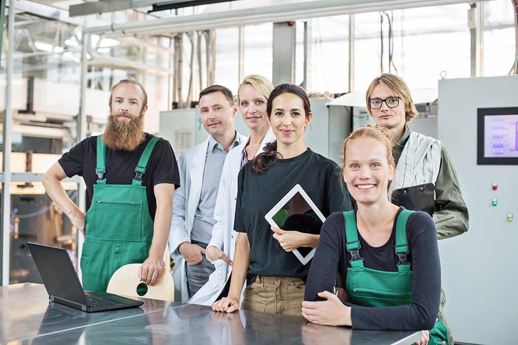 équipe de 6 personnes composée de 3 hommes et 3 femmes. Certains portent un tablier vert, d'autres une blouse blanche