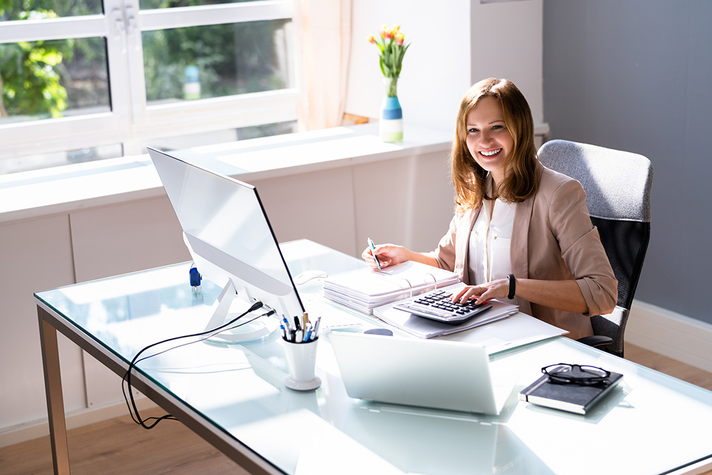 portrait d'une femme expert comptable assise derrière son pc